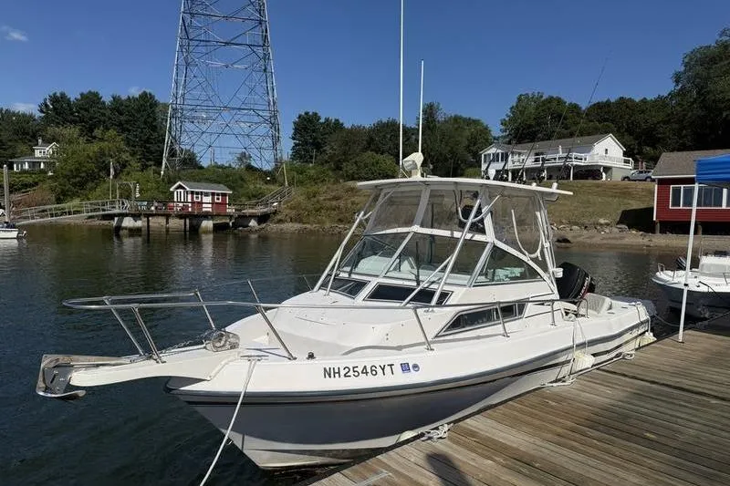 Slide: The Image of 1995 Grady-White Gulfstream 232 boat docked by a scenic waterfront. - 0