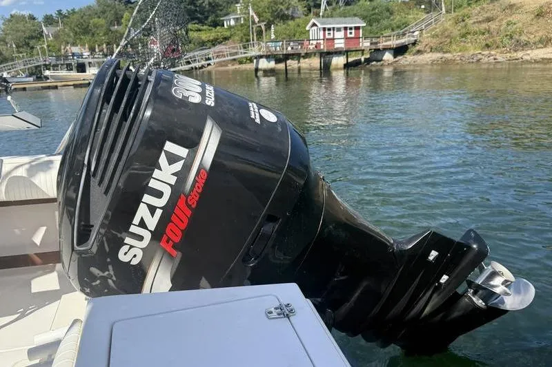 Slide: The Image of 1995 Grady-White Gulfstream 232 with Suzuki 300 outboard motor on a calm waterfront. - 2