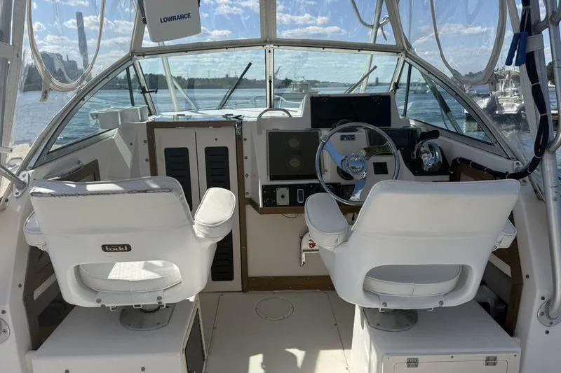 Slide: The Image of 1995 Grady-White Gulfstream 232 boat interior with helm and seating, overlooking water. - 4