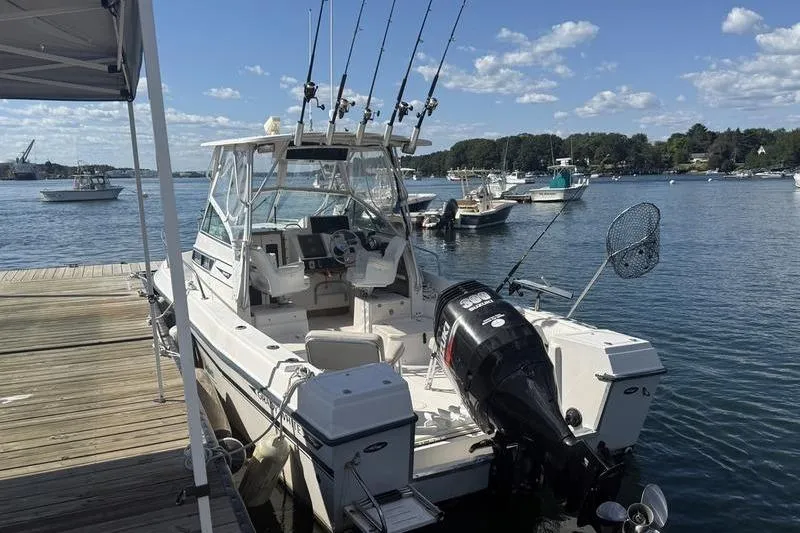 Slide: The Image of 1995 Grady-White Gulfstream 232 boat docked, equipped with fishing rods and outboard motor. - 6