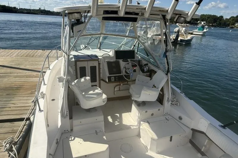 Slide: The Image of 1995 Grady-White Gulfstream 232 boat docked, featuring spacious cockpit and helm area. - 7
