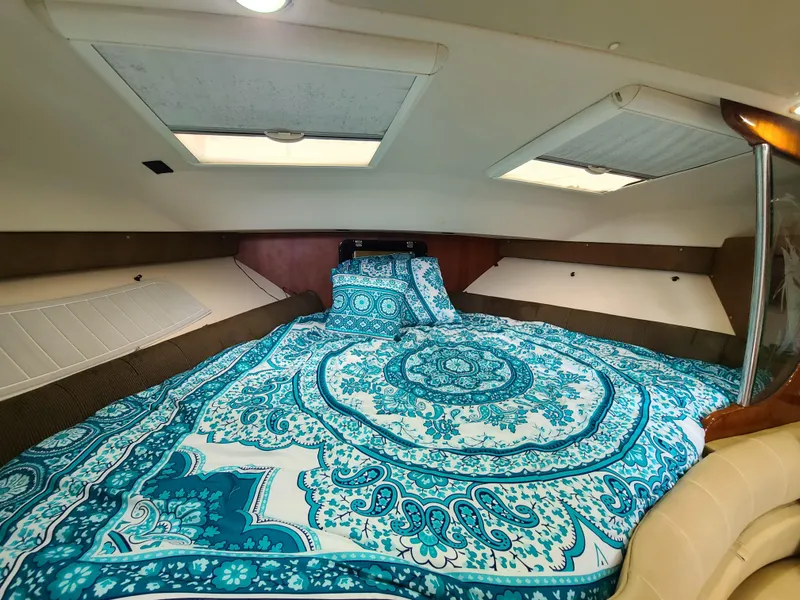 Slide: The Image of 2011 Grady-White Express 360 cabin with vibrant blue patterned bedding. - 20