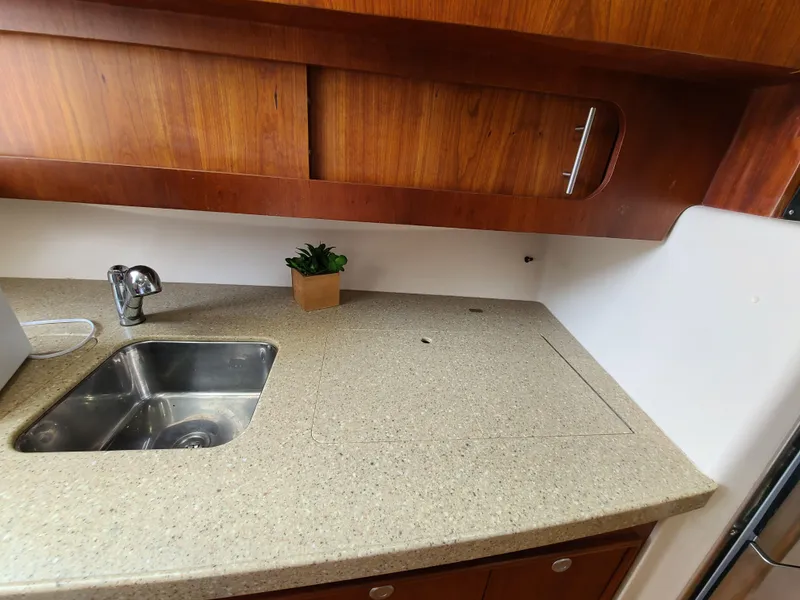 Slide: The Image of 2011 Grady-White Express 360 boat kitchen with sink and wooden cabinets. - 23