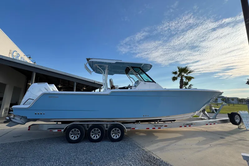 Slide: The Image of 2026 Bertram 34CC boat on trailer, blue hull, parked outdoors under clear sky. - 1