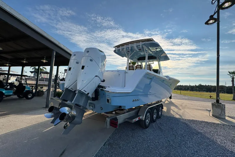 Slide: The Image of 2026 Bertram 34CC boat on trailer, featuring dual outboard engines, parked outdoors. - 11