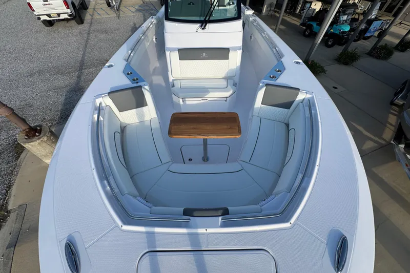 Slide: The Image of 2026 Bertram 34CC boat interior with seating and wooden table, docked outdoors. - 15