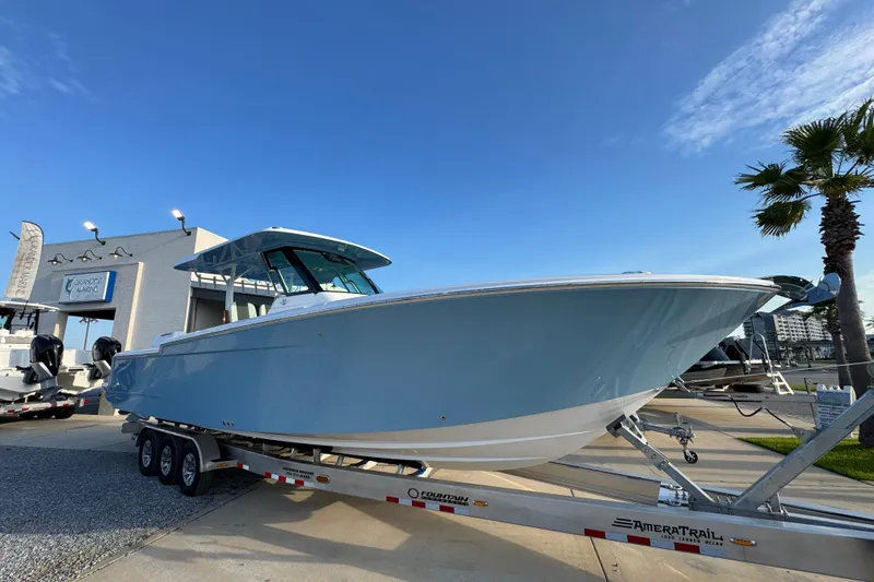 Slide: The Image of 2026 Bertram 34CC boat on trailer at marina, clear blue sky background. - 2
