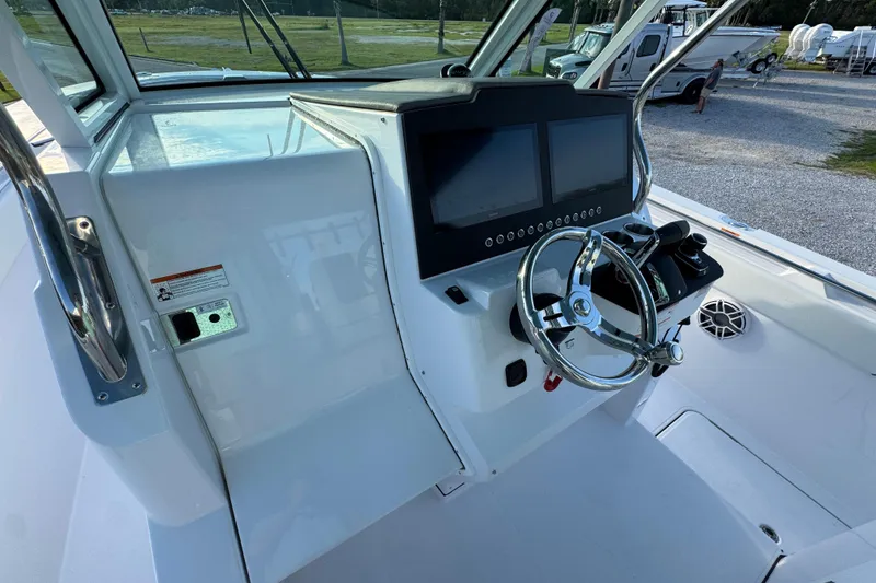 Slide: The Image of 2026 Bertram 34CC boat helm with dual screens and modern steering wheel. - 23
