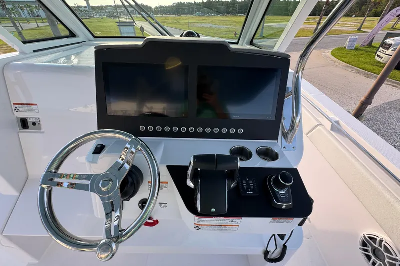 Slide: The Image of 2026 Bertram 34CC helm with dual screens, steering wheel, and control panel. - 24