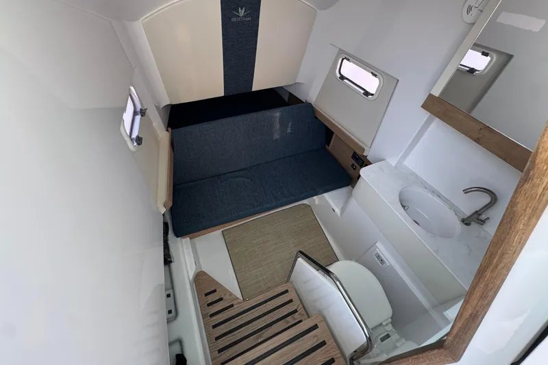 Slide: The Image of 2026 Bertram 34CC cabin interior with seating, sink, and toilet. - 27