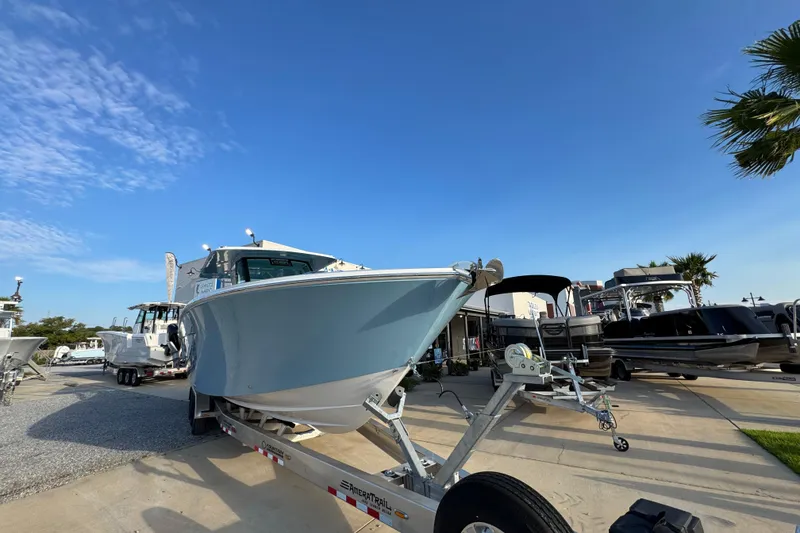 Slide: The Image of 2026 Bertram 34CC boat on trailer under clear blue sky at dealership. - 3