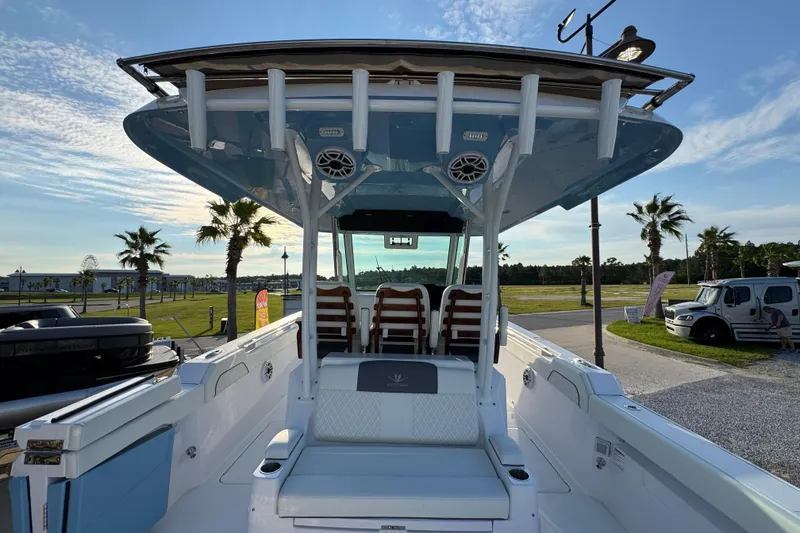 Slide: The Image of 2026 Bertram 34CC boat interior with seating, under a clear sky, surrounded by palm trees. - 33