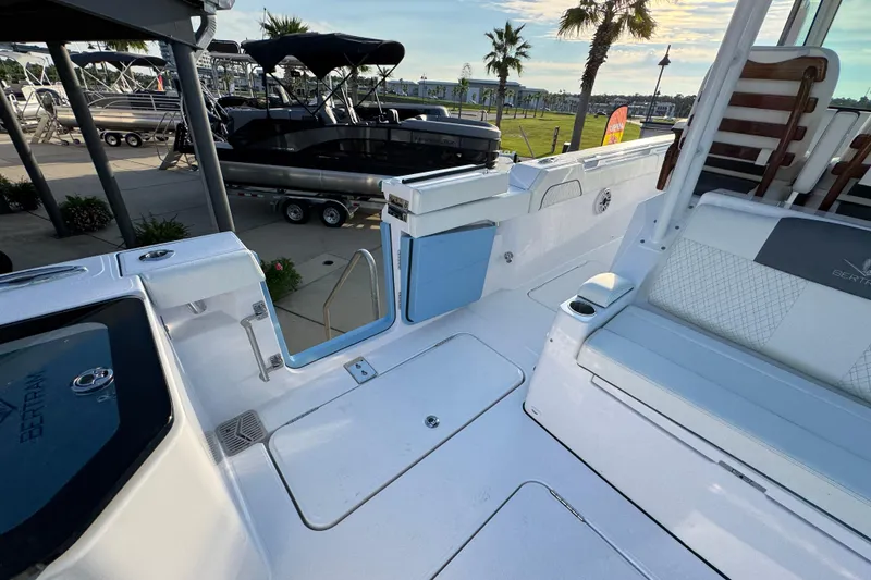 Slide: The Image of 2026 Bertram 34CC boat interior with seating and deck details, docked near palm trees. - 34