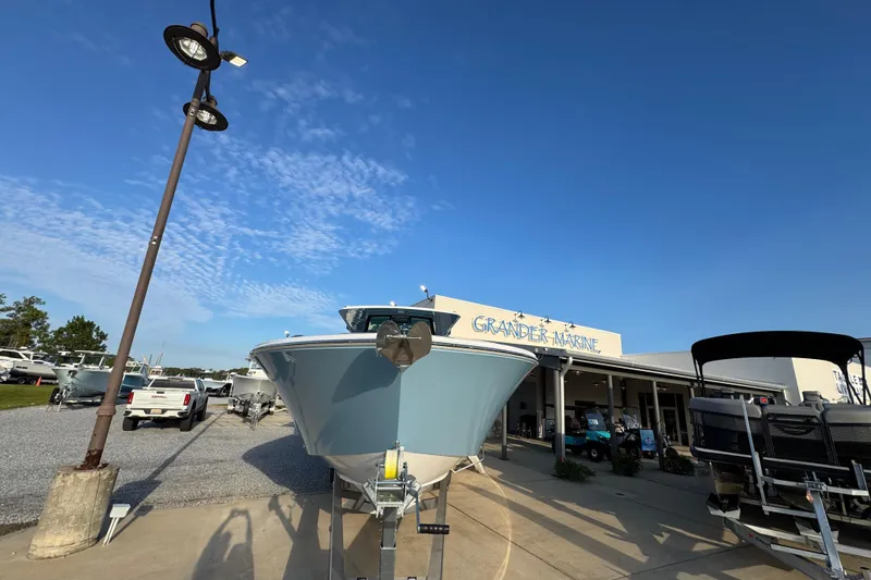 Slide: The Image of 2026 Bertram 34CC boat displayed at Grander Marine dealership under clear blue sky. - 4