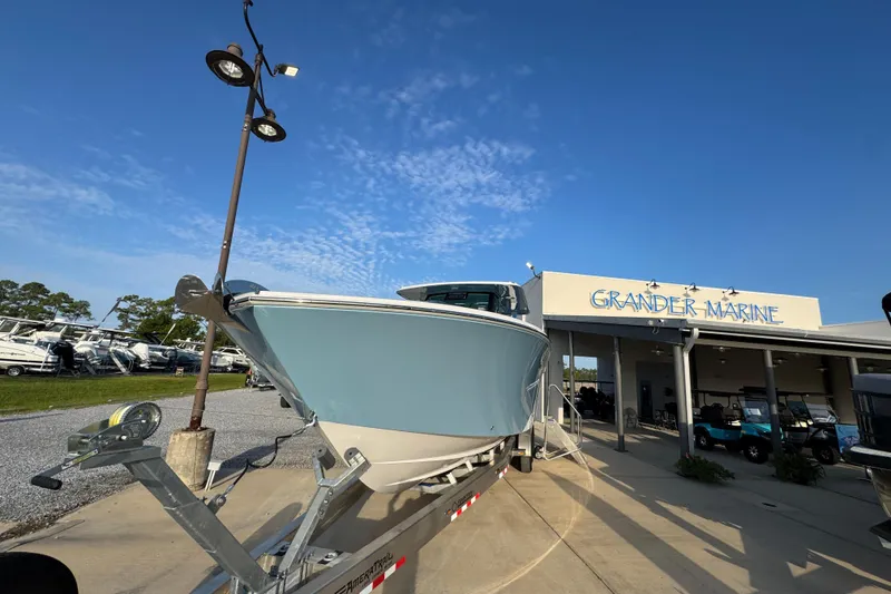 Slide: The Image of 2026 Bertram 34CC boat at Grander Marine dealership under clear blue sky. - 5