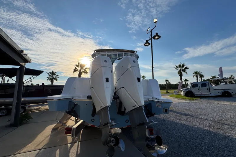 Slide: The Image of 2026 Bertram 34CC boat with dual outboard motors at sunset, palm trees in background. - 9