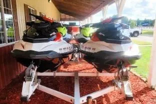 The Image of 2012 Sea-Doo Wake 155 hp jet skis on a trailer, parked outdoors. - 0