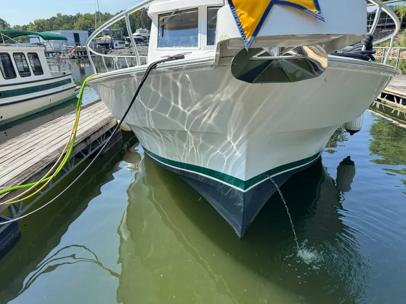 Slide: The Image of 2001 Mainship 390 boat docked at marina, reflecting on calm water. - 10