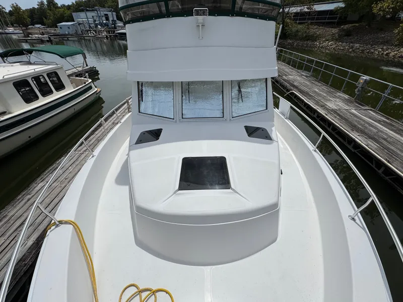 Slide: The Image of 2001 Mainship 390 boat docked at marina, view of bow and cabin windows. - 15