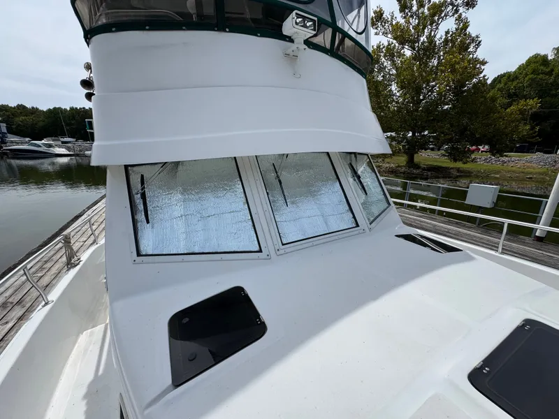 Slide: The Image of 2001 Mainship 390 boat docked, featuring front windows and deck view. - 16