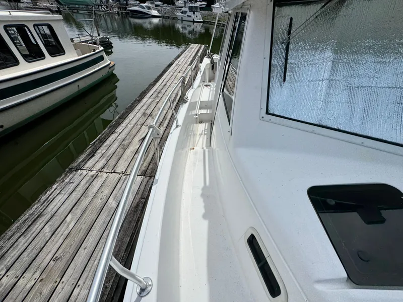 Slide: The Image of 2001 Mainship 390 yacht docked at marina, side view with wooden pier. - 19