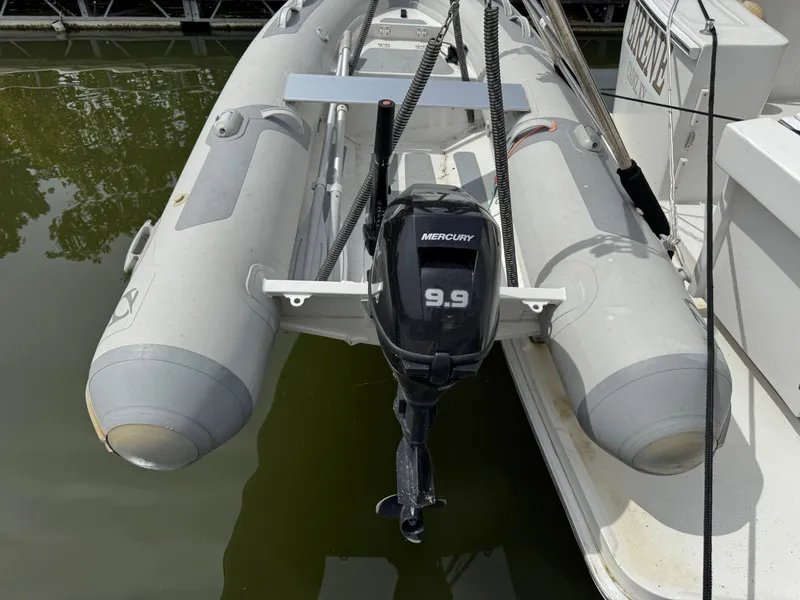 Slide: The Image of Inflatable boat with Mercury 9.9 outboard motor, docked beside Mainship 390, 2001 model. - 23