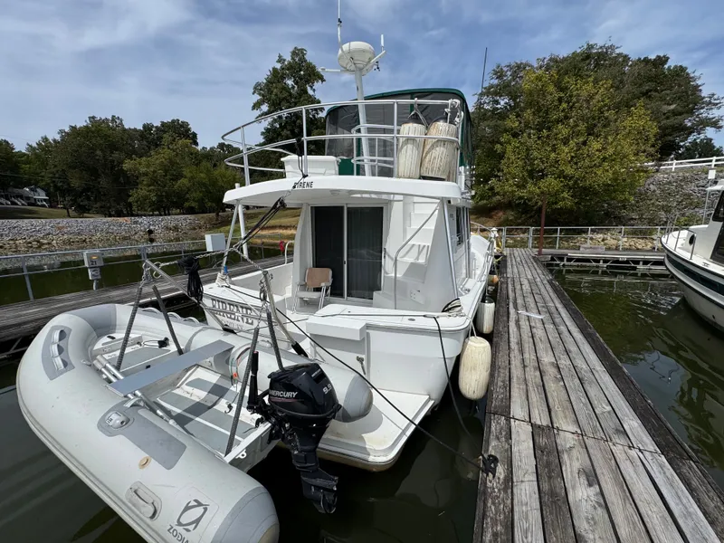 Slide: The Image of 2001 Mainship 390 docked with inflatable boat and Mercury outboard motor. - 24