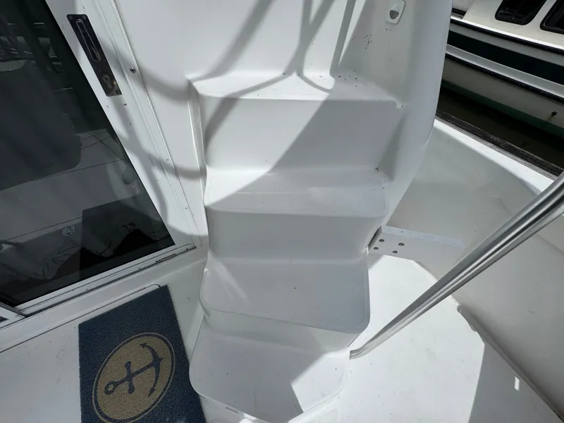 Slide: The Image of White stairs on a 2001 Mainship 390 boat with anchor-themed doormat. - 28
