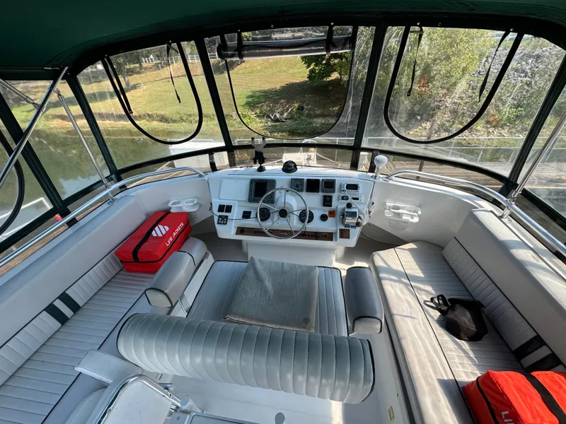 Slide: The Image of 2001 Mainship 390 boat helm with seating, steering wheel, and life jackets. - 29