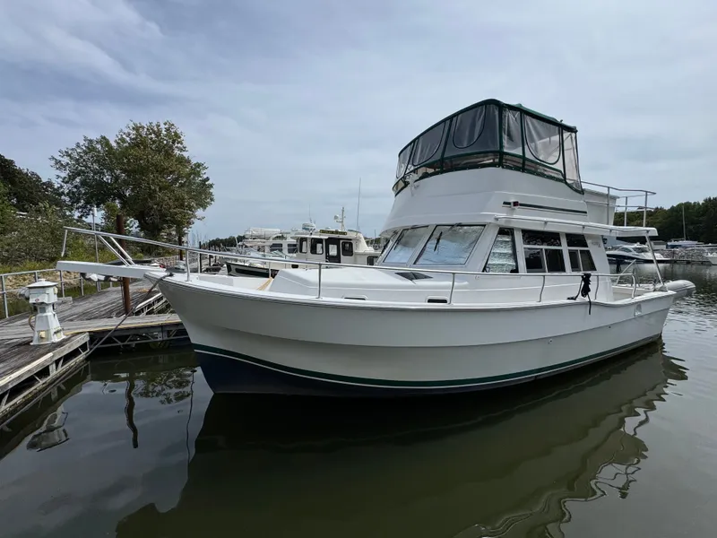 Slide: The Image of 2001 Mainship 390 yacht docked at marina, featuring spacious cabin and flybridge. - 3