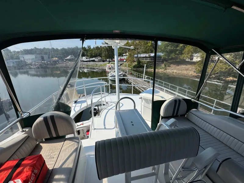Slide: The Image of 2001 Mainship 390 yacht interior with seating, docked by a calm waterfront. - 31