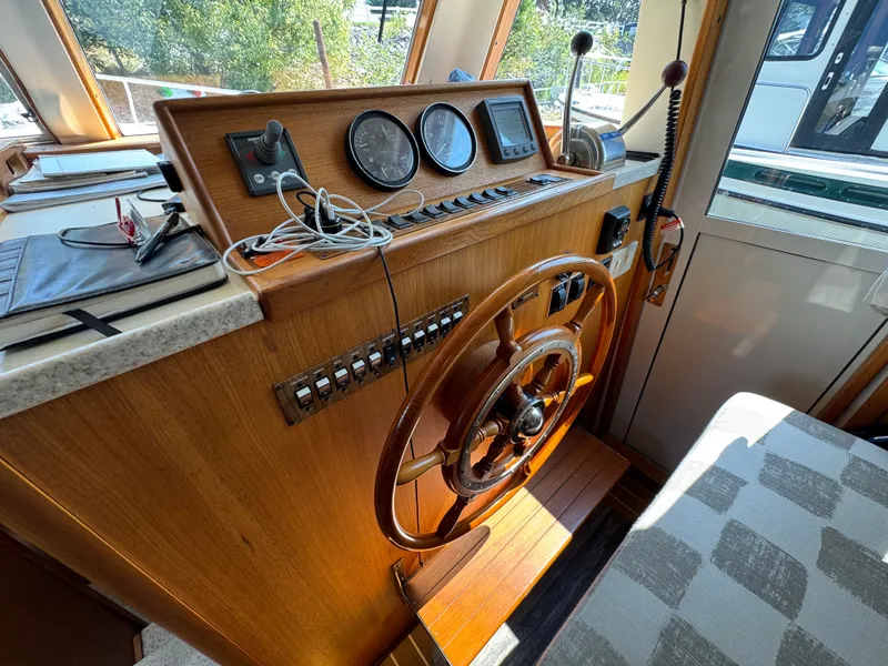 Slide: The Image of 2001 Mainship 390 helm with wooden steering wheel and navigation instruments. - 32