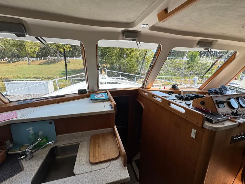 Slide: The Image of Interior view of 2001 Mainship 390 boat with helm, sink, and navigation equipment. - 33