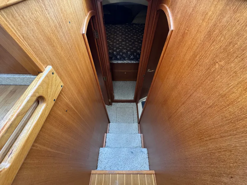 Slide: The Image of Interior view of 2001 Mainship 390 yacht, featuring wooden stairs and cozy cabin. - 34