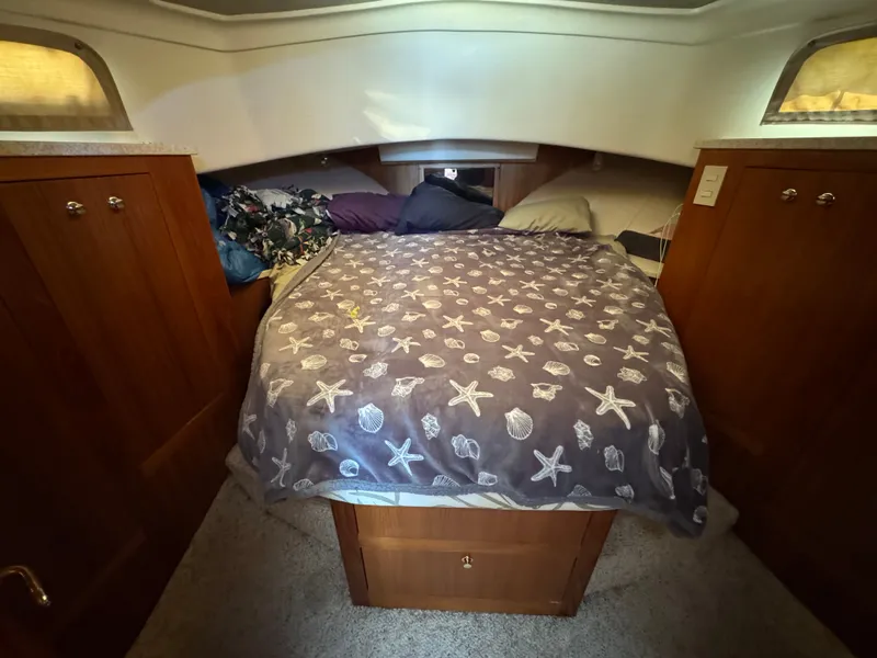 Slide: The Image of Cozy cabin bedroom in 2001 Mainship 390 yacht with starfish-patterned bedding. - 35