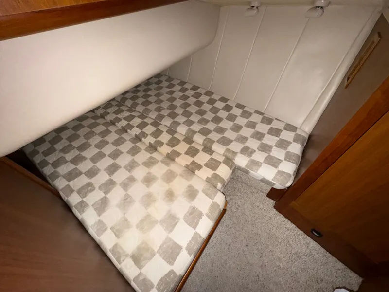 Slide: The Image of Cabin interior of 2001 Mainship 390 with checkered bedding and wood accents. - 36