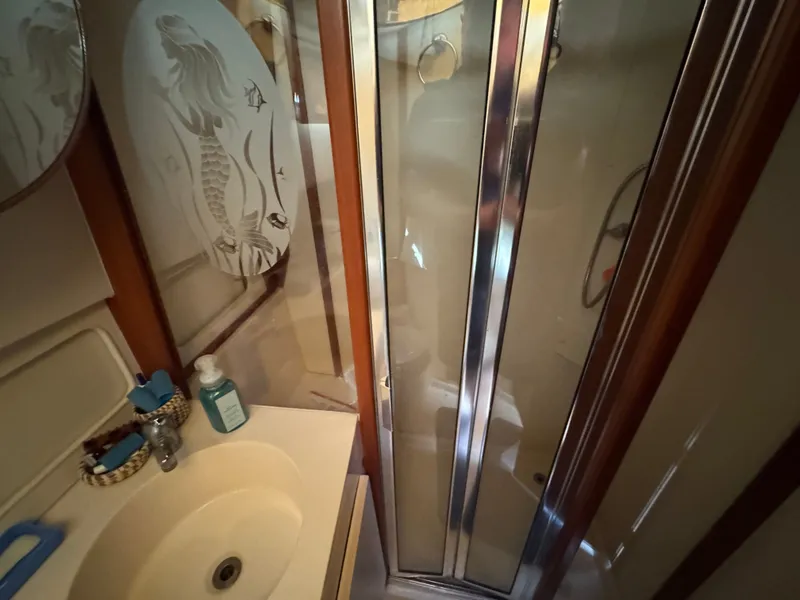 Slide: The Image of Bathroom in 2001 Mainship 390 yacht with shower and mermaid-themed decor. - 39