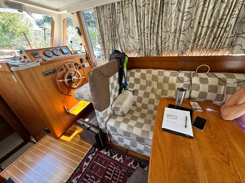 Slide: The Image of Interior of 2001 Mainship 390 boat with helm, seating, and table setup. - 40