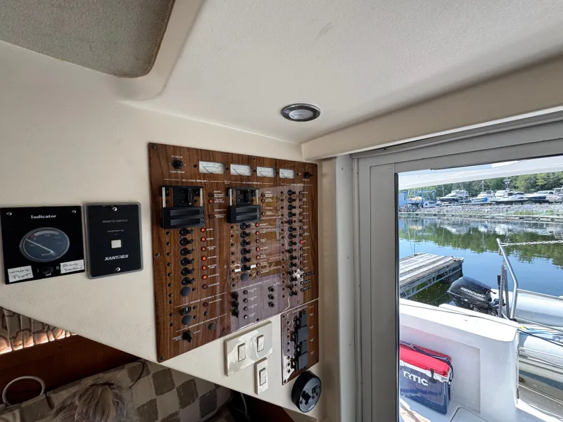 Slide: The Image of Control panel inside a 2001 Mainship 390 boat, overlooking a marina. - 43