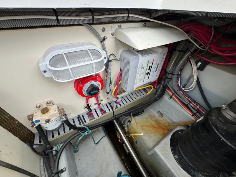 Slide: The Image of Engine compartment of a 2001 Mainship 390 with electrical components and wiring. - 44