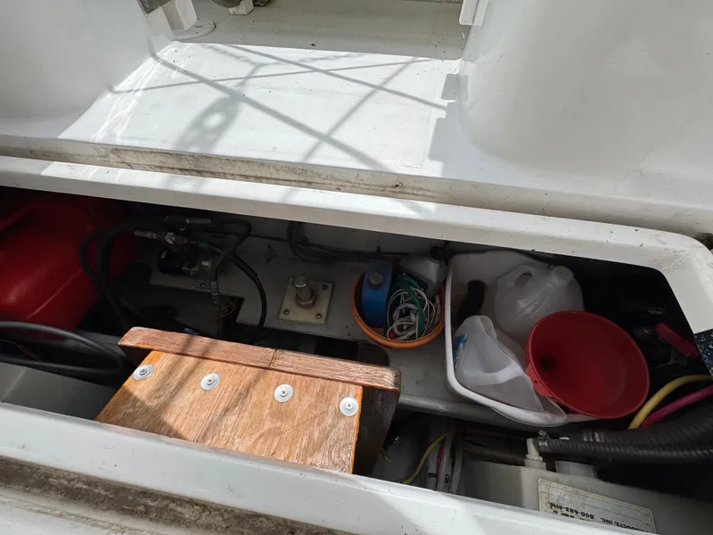 Slide: The Image of Storage compartment of a 2001 Mainship 390 boat with various tools and equipment. - 48
