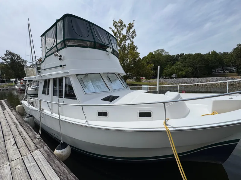 Slide: The Image of 2001 Mainship 390 yacht docked at a marina, featuring a spacious upper deck. - 7