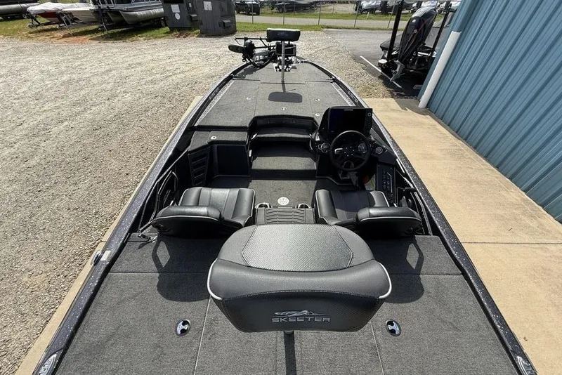 Slide: The Image of 2023 Ranger RT198P boat interior with seating and steering console, parked outdoors. - 23