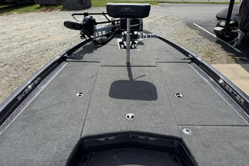 Slide: The Image of 2023 Ranger RT198P boat deck with seating and equipment, parked on gravel. - 6