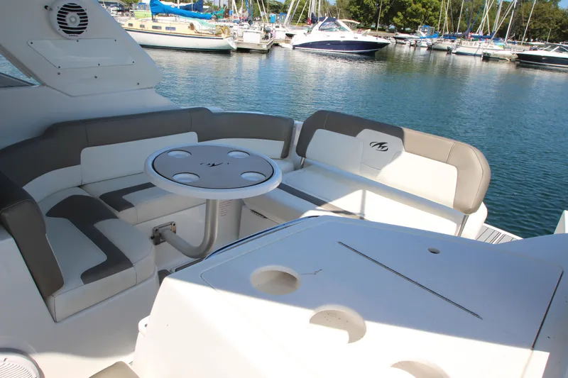 Slide: The Image of 2018 Monterey 295 Sport Yacht interior with seating and table, docked at marina. - 10