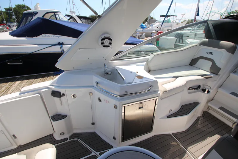 Slide: The Image of 2018 Monterey 295 Sport Yacht interior with seating and kitchenette on a sunny day. - 12