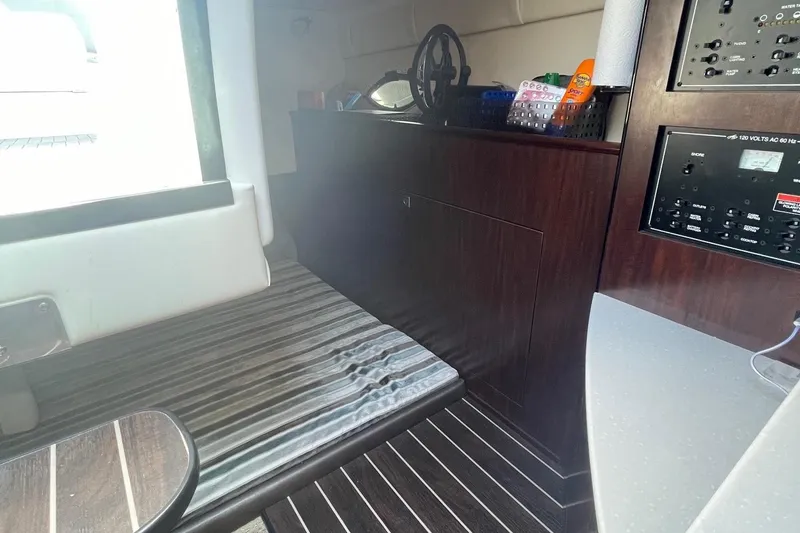 Slide: The Image of Interior of 2018 Monterey 295 Sport Yacht with striped seating and control panel. - 24