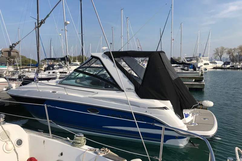 Slide: The Image of 2018 Monterey 295 Sport Yacht docked in a marina, surrounded by sailboats. - 4