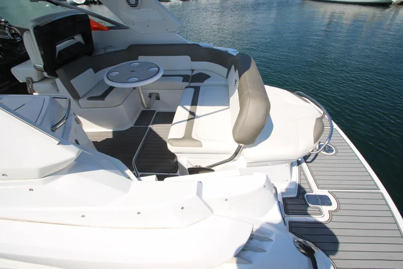 Slide: The Image of 2018 Monterey 295 Sport Yacht interior with seating and table, docked on calm water. - 9