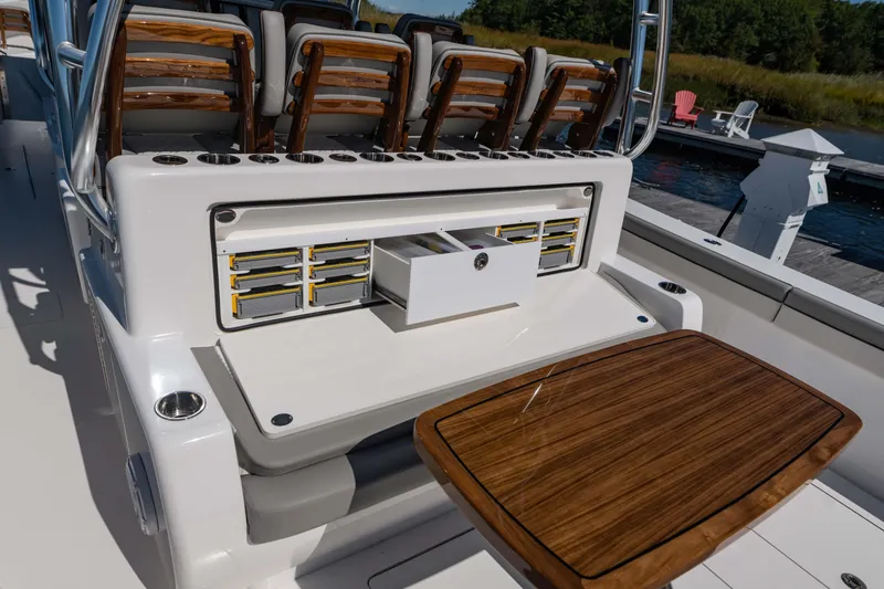 Slide: The Image of 2025 Valhalla Boatworks V-46 interior with seating and storage compartments, docked by the water. - 18